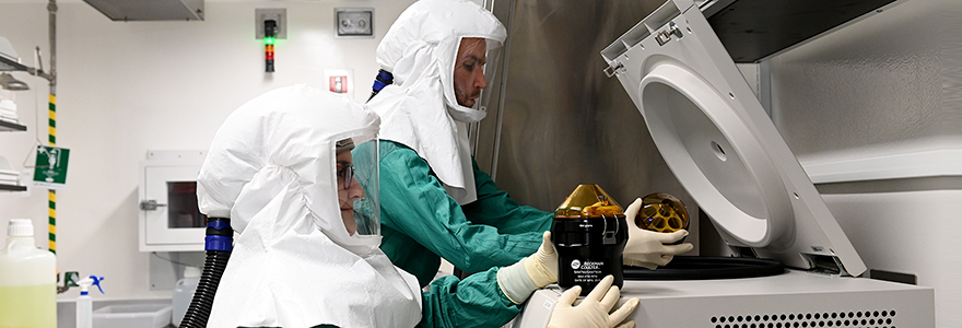 Corby Fink, PhD, and Mariya Goncheva, PhD, in full PPE, working inside the ImPaKT Facilility